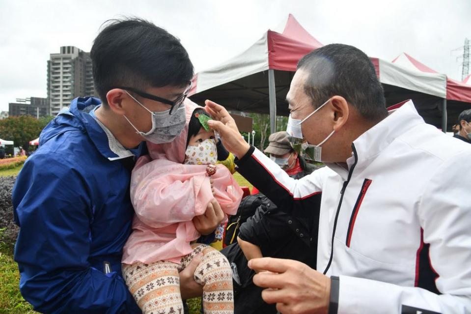 五股區公所在夏綠地園區心環原公園舉辦童樂會，新北市長侯友宜發糖果與大小朋友互動同樂。　（記者吳瀛洲攝）