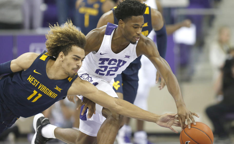 West Virginia forward Emmitt Matthews (11) attempts to steal the ball from TCU guard RJ Nembhard (22) during the first half of an NCAA college basketball game, Saturday, Feb. 22, 2020 in Fort Worth, Texas. (AP Photo/Ron Jenkins)