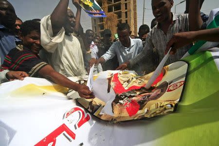 Protesters from Islamic Movement, a faction of Sudan's ruling National Congress Party, joined by Egyptians, burn a poster of Egypt's President Abdel Fattah el-Sisi during a march against an Egyptian court's decision this week to seek the death penalty for Egypt's ousted Islamist president Mohamed Mursi, after Friday prayers in Khartoum, Sudan May 22, 2015. REUTERS/Stringer