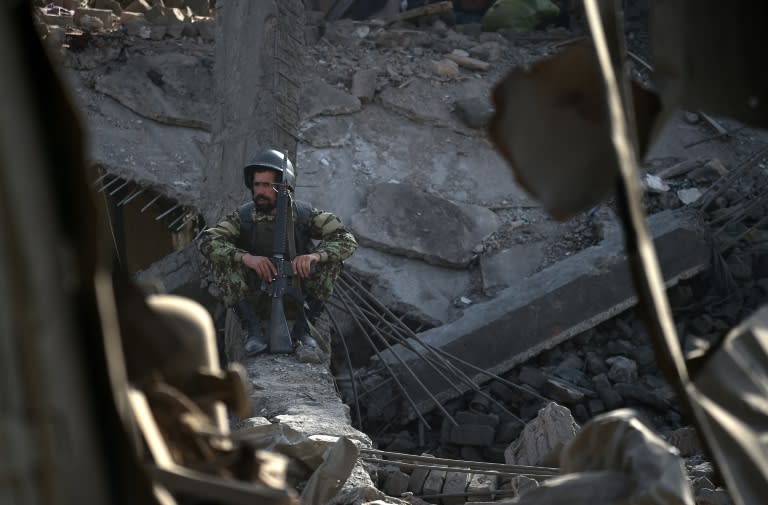 An Afghan National Army soldier sits inside a damaged building after a powerful truck bomb explosion in Kabul on August 7, 2015