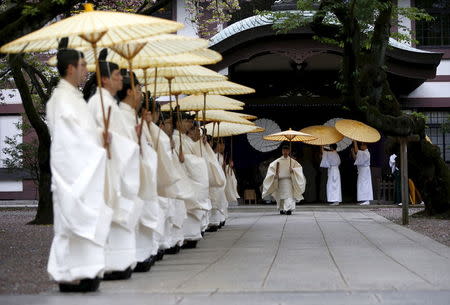 Shinto priests holding traditional umbrellas prepare to walk to the main shrine for a ritual to cleanse themselves during the annual Spring Festival at the Yasukuni Shrine in Tokyo, Japan, April 21, 2016. REUTERS/Issei Kato