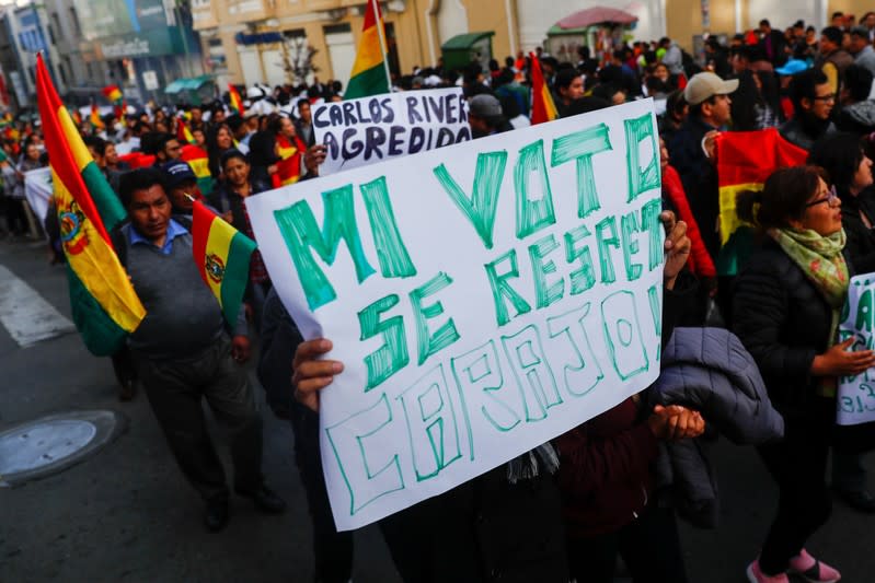 Opponents of Bolivia's President Evo Morales hold a placard reading "Respect my vote, damn it" during a protest, in La Paz