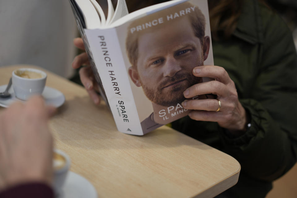 A customer reads a copy of the new book by Prince Harry called "Spare" at a book store in Rome, Tuesday, Jan. 10, 2023. Prince Harry's memoir "Spare" arrives in bookstores on Tuesday, providing a varied portrait of the Duke of Sussex and the royal family. (AP Photo/Andrew Medichini)