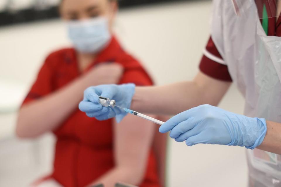 A nurse practitioner fills a needle with the Covid-19 vaccine before administering it to Sister Joanna Sloan (left), the first person in Northern Ireland to receive the first of two Pfizer/BioNTech Covid-19 vaccine jabs, at the Royal Victoria Hospital, in Belfast, on the first day of the largest immunisation programme in the UK’s history. Care home workers, NHS staff and people aged 80 and over will begin receiving the jab from Tuesday. (PA Archive)