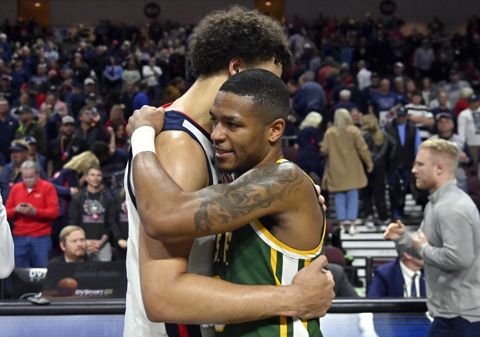 Gonzaga forward Anton Watson, left, and San Francisco guard Khalil Shabazz embrace after an NCAA college basketball game in the semifinals of the West Coast Conference men's tournament Monday, March 6, 2023, in Las Vegas. (AP Photo/David Becker)