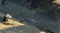 Emergency responders investigate the scene of a crash, Thursday, Feb. 22, 2024 on U.S. 287 about 10 miles (16 kilometers) south of the Wyoming-Colorado line between Laramie and Fort Collins, Colo. Three members of the University of Wyoming swimming and diving team were killed in the crash. (KMGH Denver7 via AP)