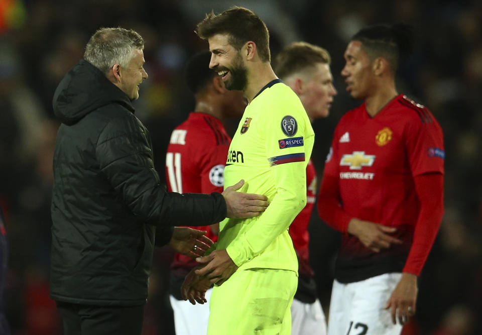 Manchester United coach Ole Gunnar Solskjaer, left, talks with Barcelona's Gerard Pique at the end of the Champions League quarterfinal, first leg, soccer match between Manchester United and FC Barcelona at Old Trafford stadium in Manchester, England, Wednesday, April 10, 2019. (AP Photo/Dave Thompson)