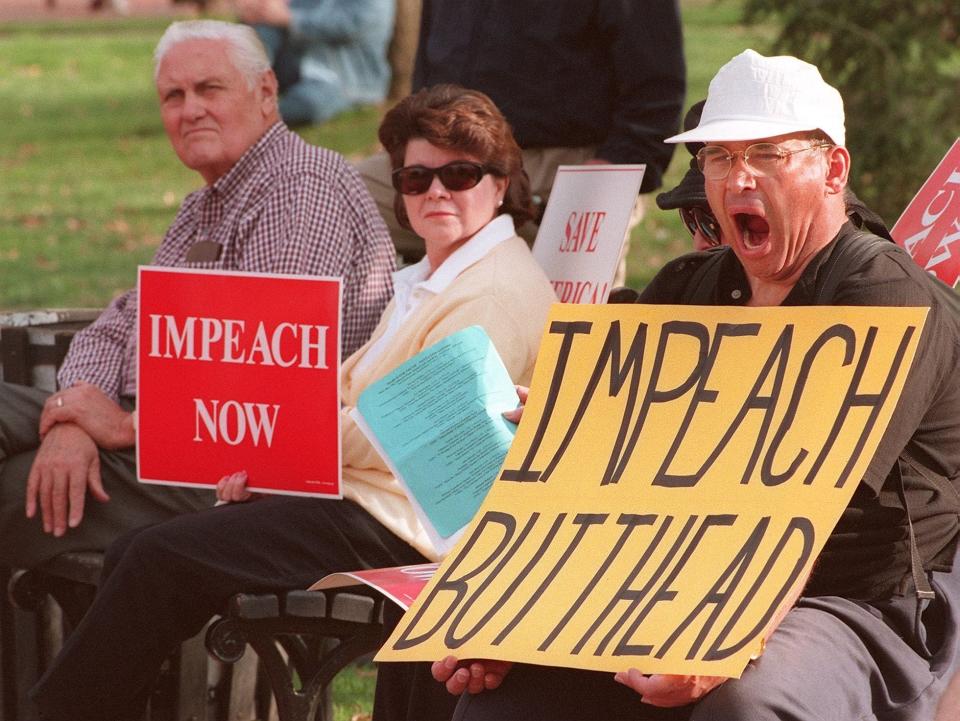 Unidentified protestors demanding the impeachment of US President Bill Clinton conduct their noontime protest from the park benches in Lafayette Park across from the White House 07 December. Clinton's lawyers 