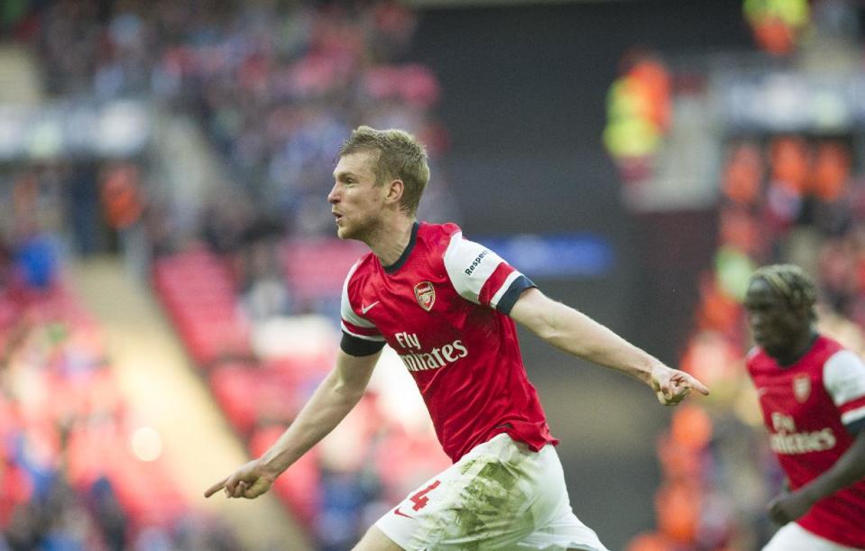 Arsenal's Per Mertesacker, celebrates after scoring against Wigan Athletic, during their English FA Cup semifinal soccer match, at the Wembley Stadium in London, Saturday, April 12, 2014. (AP Photo/Bogdan Maran)