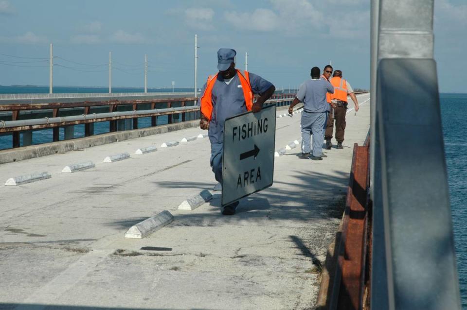 A crew from the Florida Department of Transportation removes Fishing Area signs from the crumbling Old Seven Mile Bridge on June 13, 2008.