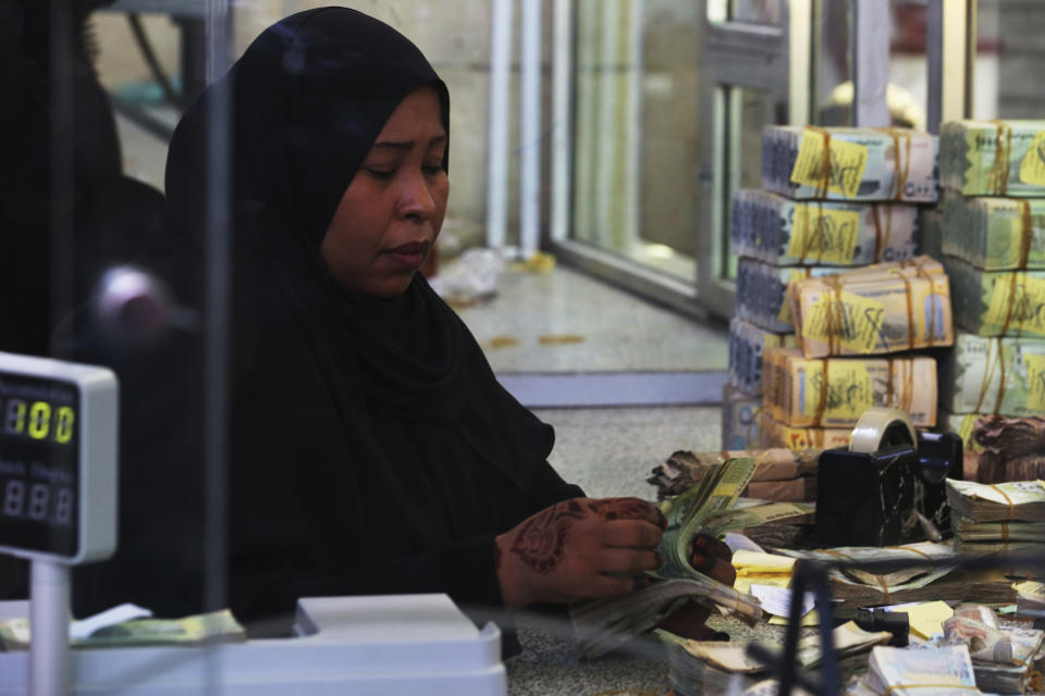 A cashier works at the Central Bank of Yemen's internationally recognized government in Aden, Yemen, Thursday, Dec. 13, 2018. A sense of normalcy has returned to Aden, now the seat of power for Yemen's internationally recognized government, but many challenges remain for bringing a lasting peace to the Arab world's poorest country. (AP Photo/Jon Gambrell)