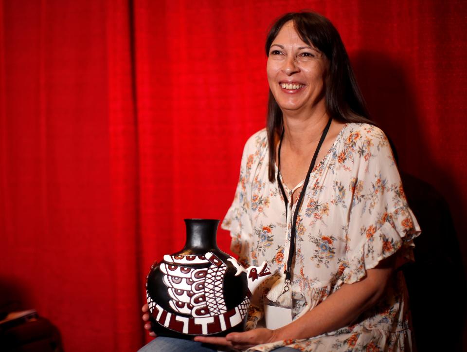 Cherokee potter Karin Walkingstick shows her winning pot, "Uktena," at her booth during the 2021 Red Earth Festival at Grand Casino & Hotel Resort in Shawnee.