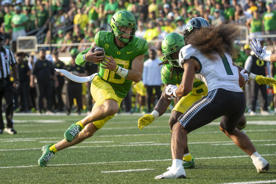 Oregon quarterback Bo Nix (10) runs the ball as Hawaii defensive back Peter Manuma looks to stop him during the first half of an NCAA college football game Saturday, Sept. 16, 2023, in Eugene, Ore. (AP Photo/Andy Nelson)