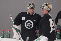 Dallas Stars goaltenders Ben Bishop (30) and Jake Oettinger (29) chat during a break in an NHL hockey practice in Frisco, Texas, Thursday, Sept. 23, 2021. (AP Photo/LM Otero)