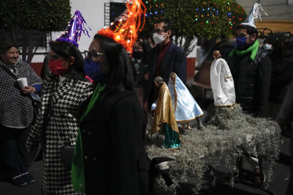 Residents participate in the procession of "Ninopan" during a Christmas "posada," which means lodging or shelter, in the Xochimilco borough of Mexico City, Wednesday, Dec. 21, 2022. For the past 400 years, residents have held posadas between Dec. 16 and 24, when they take statues of baby Jesus in procession to church for Mass to commemorate Mary and Joseph's cold and difficult journey from Nazareth to Bethlehem in search of shelter. (AP Photo/Eduardo Verdugo)