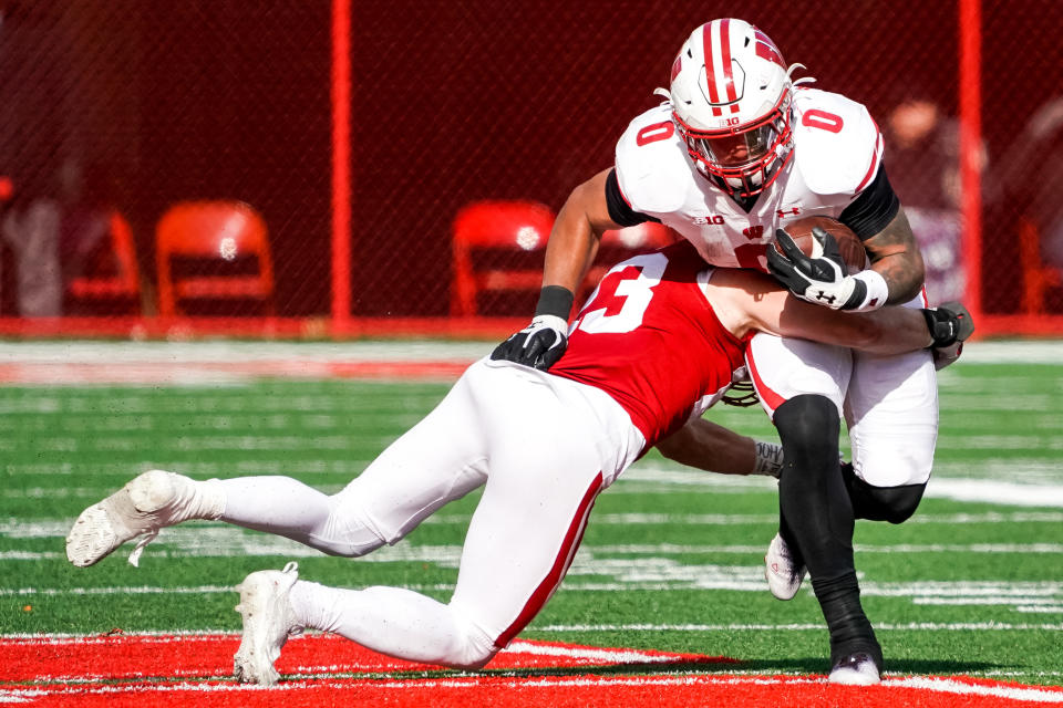 Nov 19, 2022; Lincoln, Nebraska, USA; Wisconsin Badgers running back Braelon Allen (0) is tackled by Nebraska Cornhuskers nickel back Isaac Gifford (23) during the fourth quarter at Memorial Stadium. Mandatory Credit: Dylan Widger-USA TODAY Sports