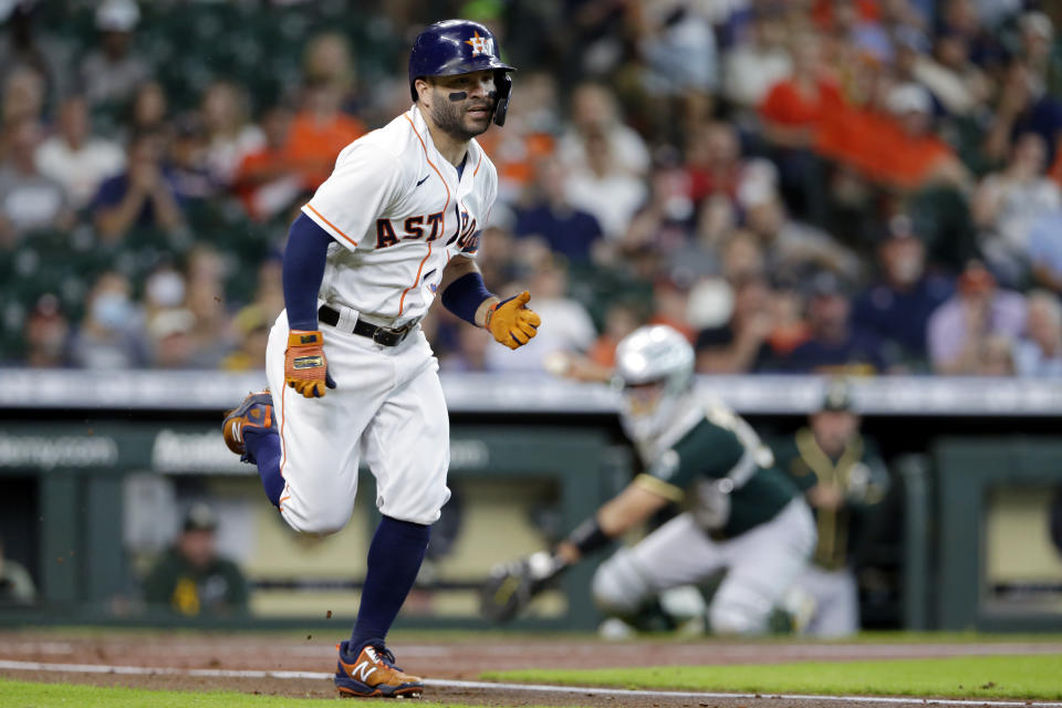 Houston Astros second baseman Jose Altuve, left, hustles to first base as Oakland Athletics catcher Aramis Garcia, right, prepares to throw to first base for the out during the third inning of a baseball game Thursday, July 8, 2021, in Houston. (AP Photo/Michael Wyke)