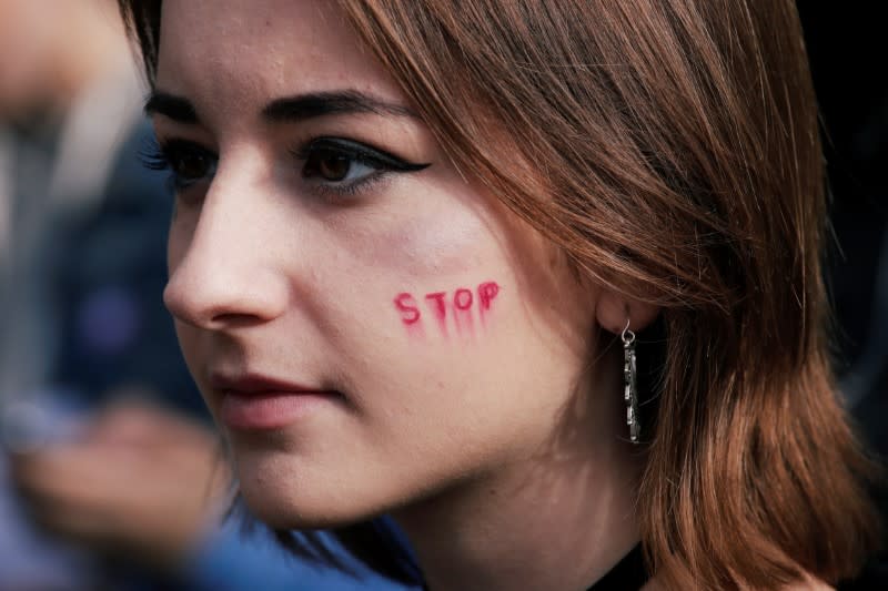 A woman attends a demonstration against femicide and violence against women at Place de la Republique in Paris
