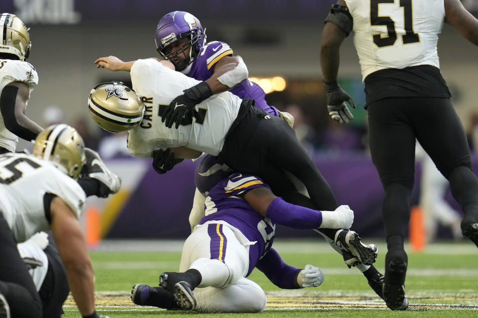 New Orleans Saints quarterback Derek Carr (4) is hit by Minnesota Vikings linebacker Danielle Hunter, top, during the second half of an NFL football game Sunday, Nov. 12, 2023, in Minneapolis. Carr was injured on the play. (AP Photo/Abbie Parr)