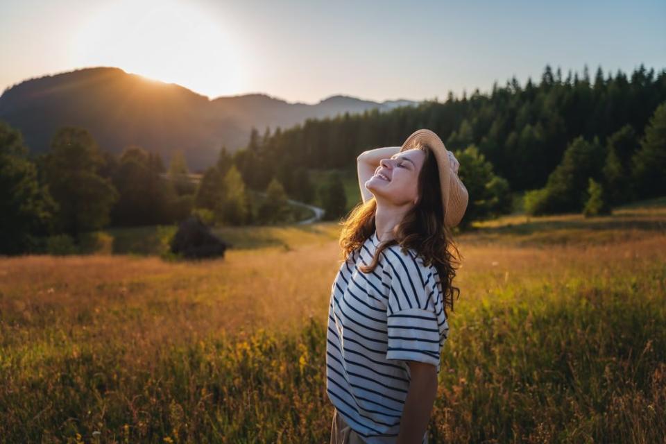 mujer joven con sombrero feliz en el campo