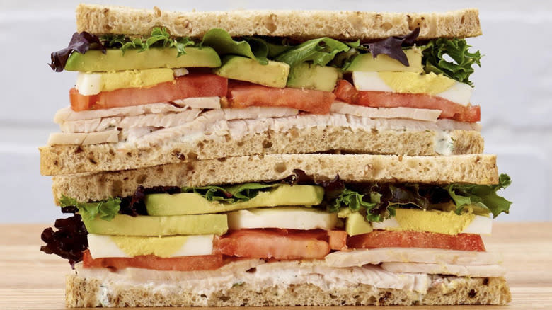 Deli sandwich with veggies on thinly sliced bread