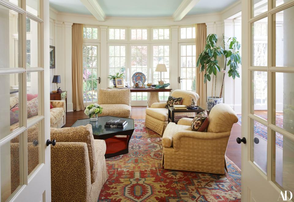 Part of the renovations, this expansive solarium was added to the original footprint of the modest home. It’s a favorite spot for Ms. Clinton to meet with people, lie down and read, or take a nap. Two velvet tiger-print chairs and an antique Serapi rug are part of a larger color story of warm reds and caramels that are meant to be both inviting and cozy. The table at the window showcases mementos that include a personalized photo of King Hussein and Queen Noor of Jordan, as well as an Ardmore Ceramics teapot gifted by Nelson Mandela.