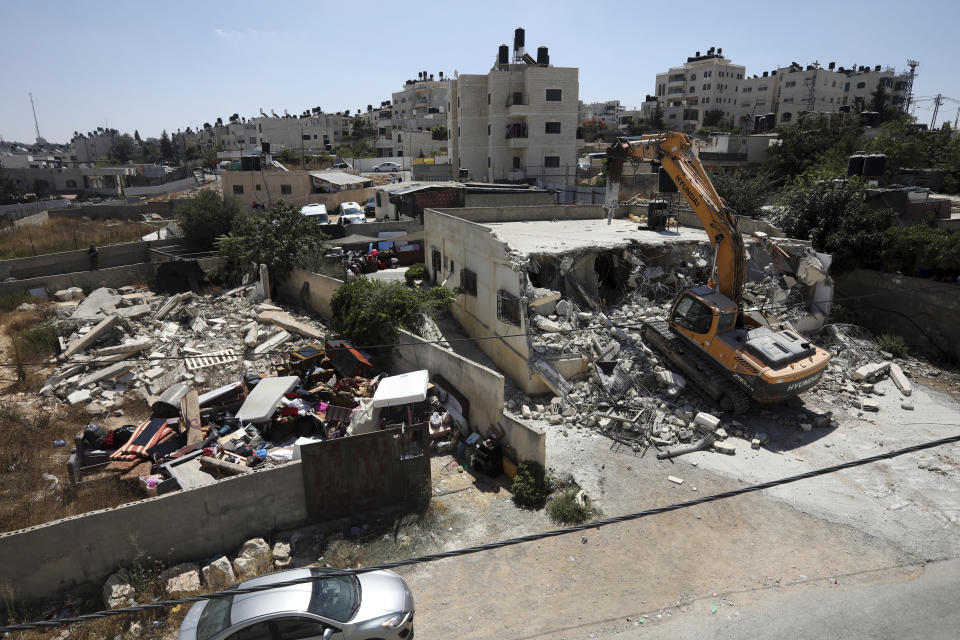 Israeli authorities demolish a Palestinian owned house in east Jerusalem, Wednesday, Aug. 21, 2019. Jerusalem's municipality has carried out the court-ordered demolition of what it said was an illegally built Palestinian home in the city's eastern sector. Jerusalem's Palestinian population has long complained that it faces discriminatory housing policies that favor Jews. They say it is virtually impossible to get a building permit and have no choice but to build without them.(AP Photo/Mahmoud Illean)