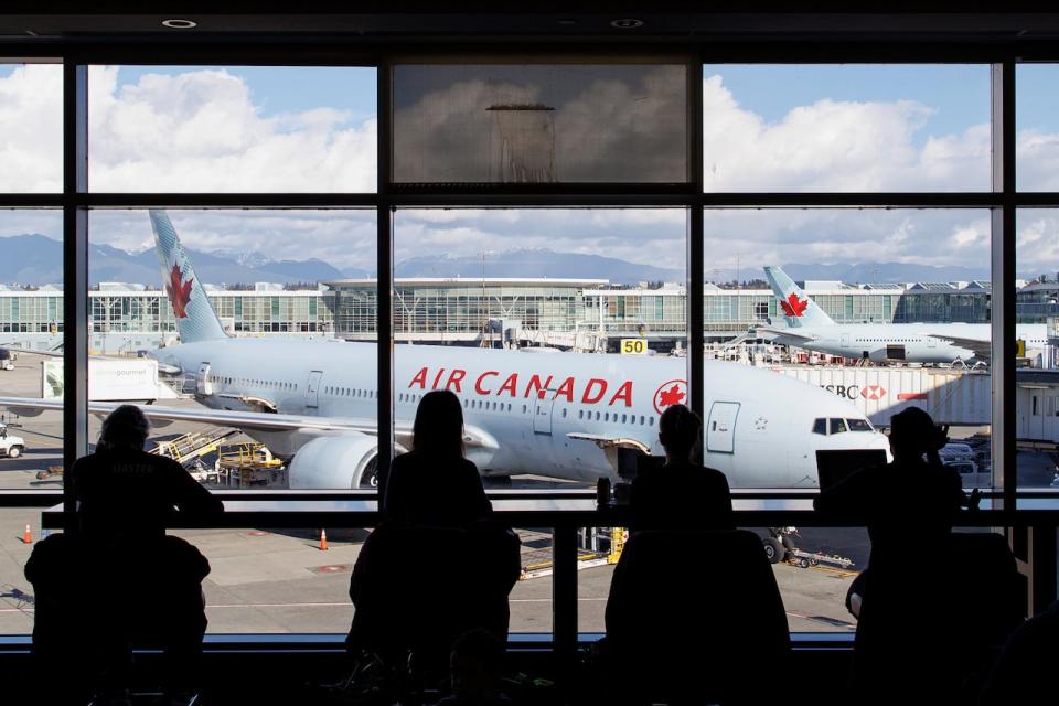 Travellers waiting in a departures lounge at Vancouver International Airport, in Richmond, B.C., on Nov. 5, 2022.