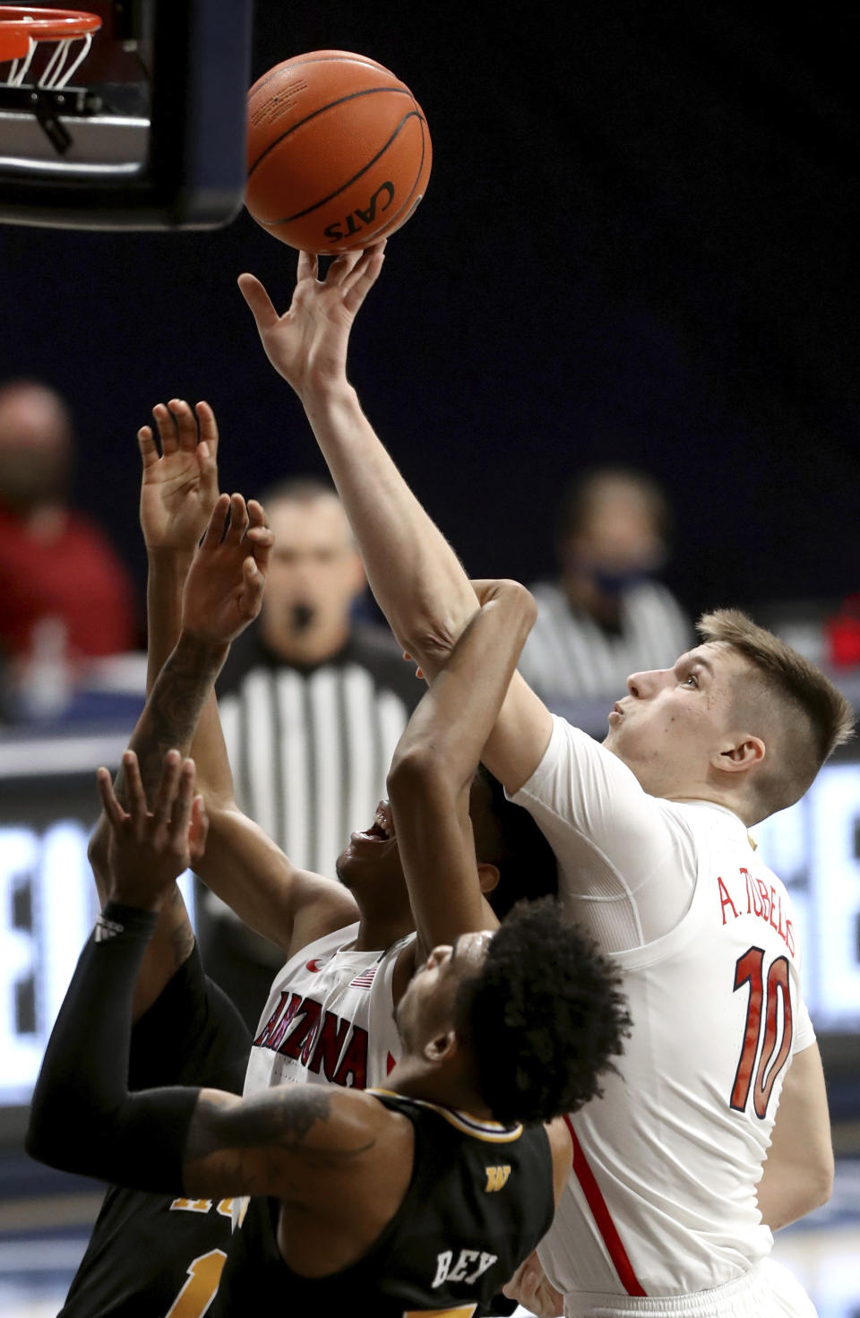 Arizona forward Azuolas Tubelis (10, right, gets tangled with teammate guard Dalen Terry (4) in front of Washington guard Jamal Bey (5) while trying to drag down a rebound in the first half of an NCAA college basketball game Saturday, Feb. 27, 2021, in Tucson, Ariz. (Kelly Presnell/Arizona Daily Star via AP)