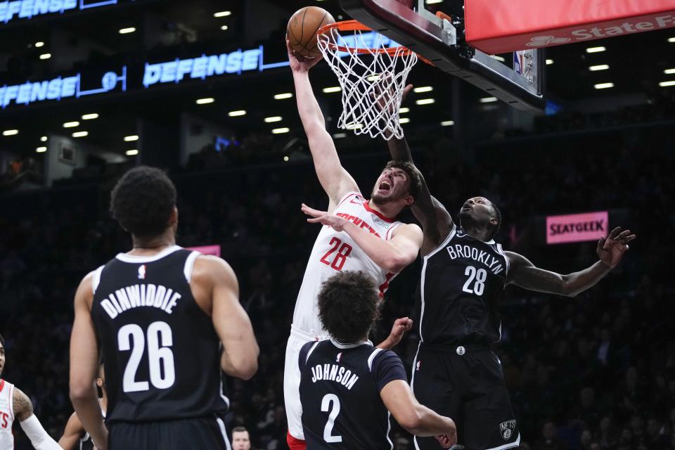 Houston Rockets' Alperen Sengun (28) dunks the ball in front of Brooklyn Nets' Dorian Finney-Smith (28) as Cameron Johnson (2) and Spencer Dinwiddie (26) watch during the first half of an NBA basketball game, Wednesday, March 29, 2023, in New York. (AP Photo/Frank Franklin II)