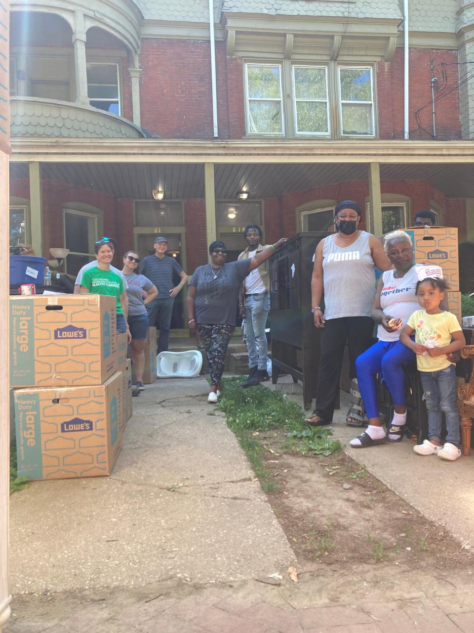 Residents of North Adams Street in Wilmington, Delaware pose with volunteers who helped them move their belongings out of apartments on Saturday, June 4, 2022.