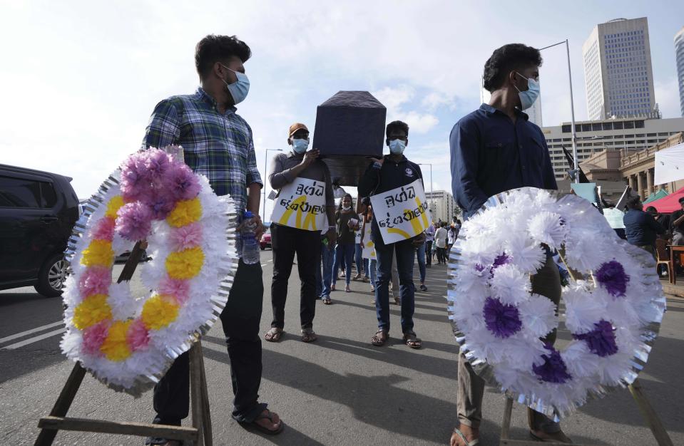 Demonstrators carrying a coffin during an ongoing protest outside president's office in Colombo, Sri Lanka, Saturday, April 23, 2022. Thousands of Sri Lankans have protested outside President Gotabaya Rajapaksa’s office in recent weeks, demanding that he and his brother, Mahinda, who is prime minister, quit for leading the island into its worst economic crisis since independence from Britain in 1948. (AP Photo/Eranga Jayawardena)