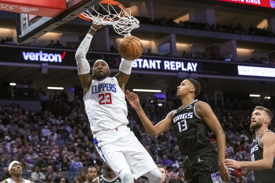 Los Angeles Clippers forward Robert Covington (23) dunks next to Sacramento Kings forward Keegan Murray (13) during the second half of an NBA basketball game in Sacramento, Calif., Saturday, Oct. 22, 2022. The Clippers won 111-109. (AP Photo/Randall Benton)