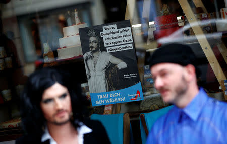 German drag artists Jacky-oh Weinhaus (L) and Buffalo Meus are pictured in front of a poster as theyparody the anti-Immigrant Alternative for Germany (AfD) party by setting up a fictional party called Travestie for Germany (TfD) in Berlin, Germany, August 24, 2017. REUTERS/Fabrizio Bensch