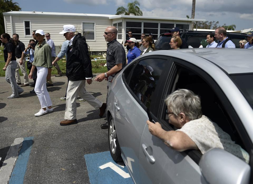 People watch as Trump tours a neighborhood damaged by Hurricane Irma in Naples.&nbsp;