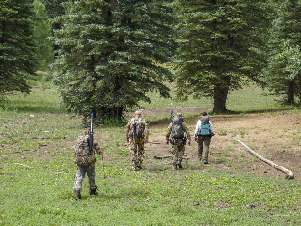 In this photo taken Aug. 11, 2021, and provided by the National Park Service, a crew led by the National Park Service heads out on the Grand Canyon's North rim in Arizona, in a trial run to shoot a bison. The agency wrapped up a pilot program this fall that allowed select volunteers to shoot bison to help reduce the animal's population and make them less comfortable at the Grand Canyon. (Michael Quinn/National Park Service via AP)