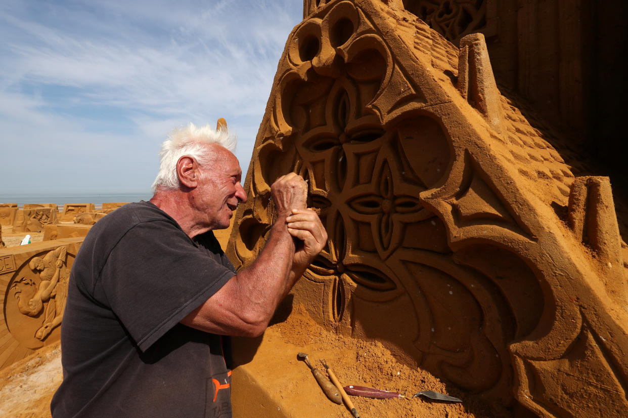 A sand carver works on a sculpture during the Sand Sculpture Festival "Dreams" in Ostend, Belgium June 18, 2019. (Photo: Yves Herman/Reuters)