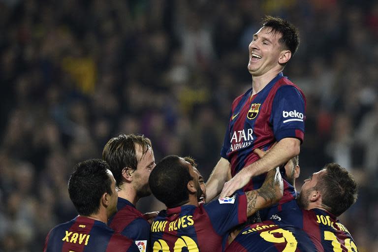 Barcelona's Argentinian forward Lionel Messi (top) celebrates with teammates after setting a new La Liga goalscoring record, during their Spanish La Liga match against Sevilla, at the Camp Nou stadium in Barcelona, on November 22, 2014