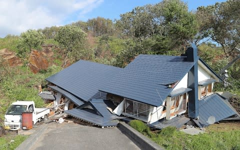 A house damaged by a landslide caused by an earthquake is seen in Atsuma town in Hokkaido prefecture - Credit: AFP