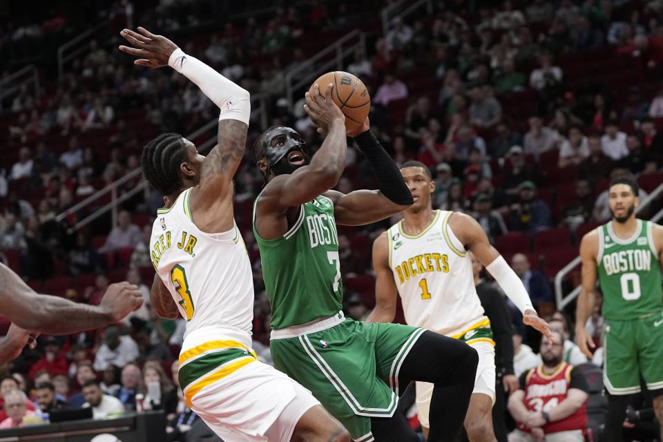 Boston Celtics' Jaylen Brown (7) goes up for a shot as Houston Rockets' Kevin Porter Jr. (3) defends during the first half of an NBA basketball game Monday, March 13, 2023, in Houston. (AP Photo/David J. Phillip)