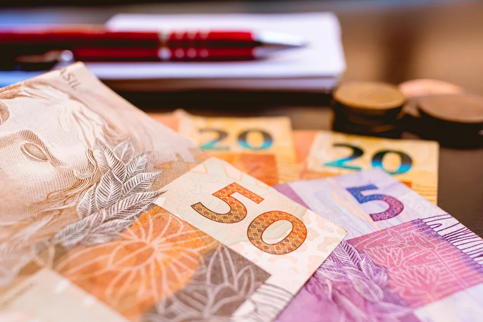 Real - Brazilian Currency. Money, Dinheiro, Brasil, Reais. A group of Real Banknotes and Real coins on a table.