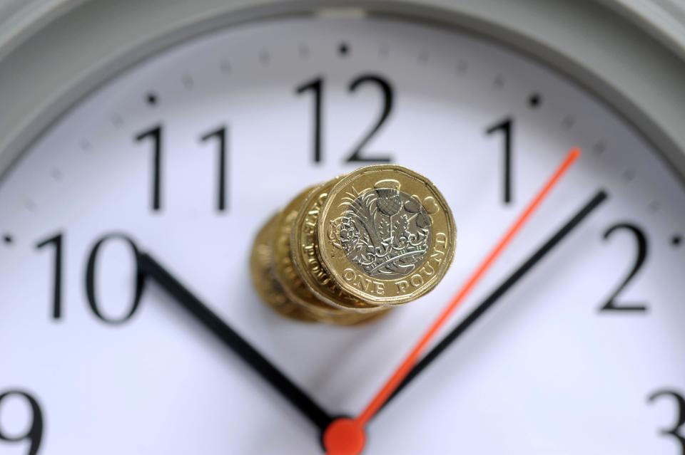 tax  STACK OF ONE POUND COINS ON CLOCK FACE RE COST OF LIVING CRISIS PENSIONS INCOME INFLATION HOUSEHOLD BUDGETS ETC UK