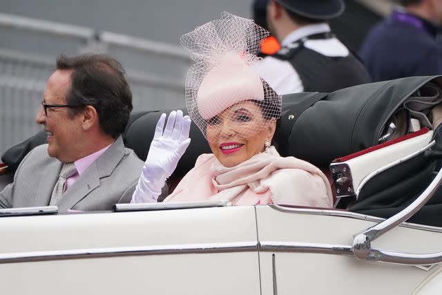 <p>Jonathan Brady - WPA Pool/Getty </p> Joan Collins and her husband Percy Gibson take part in the Platinum Jubilee Pageant on June 5, 2022.