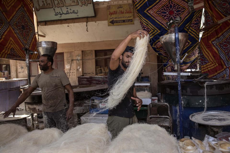 El futbolista Mahrous Mahmoud trabajando en un local que produce dulces en Manfalut, Egipto, el 9 de mayo del 2020. Mahmoud milita en el líder de la segunda división del fútbol egipcio, pero trabaja en lo que puede mientras el campeonato está paralizado por el coronavirus. (AP Photo/Nariman El-Mofty)