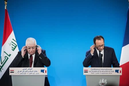 French President Francois Hollande (R) and Iraq's President Fuad Massum listen to translations during the International Conference on Peace and Security in Iraq bringing together about 30 countries to discuss how to cooperate in the fight against Islamic State militants on September 15, 2014 in Paris. REUTERS/Brendan Smialowski/Pool