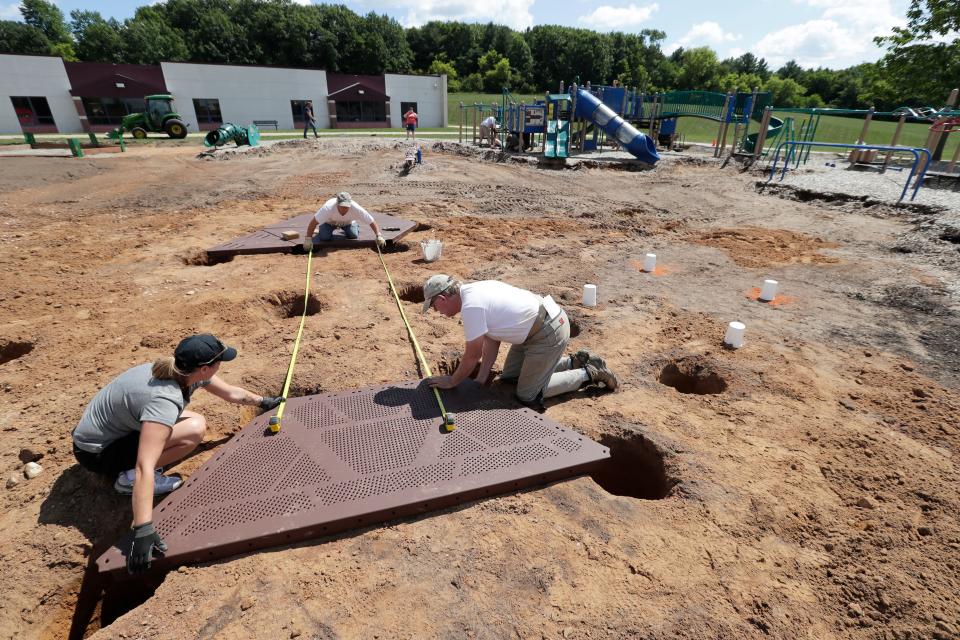 Co-organizer Kelly Gust, left, volunteer Tom Brunner, center, and Gerry Starr, with Little Tykes Commercial, measure platforms for the new playground structure at Hortonville Elementary School in August 2023.