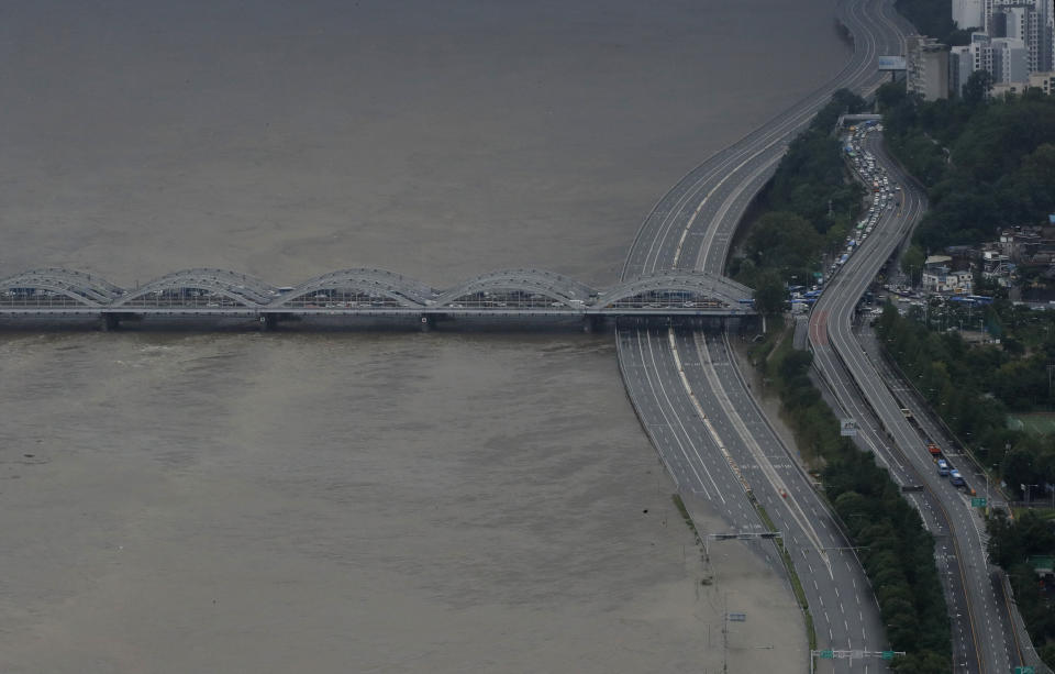 A part of a main road near the Han River is flooded due to heavy rain in Seoul, South Korea, Thursday, Aug. 6, 2020. The state-run Han River Flood Control Office issued a flood alert near a key river bridge in Seoul, the first such advisory since 2011. (AP Photo/Lee Jin-man)