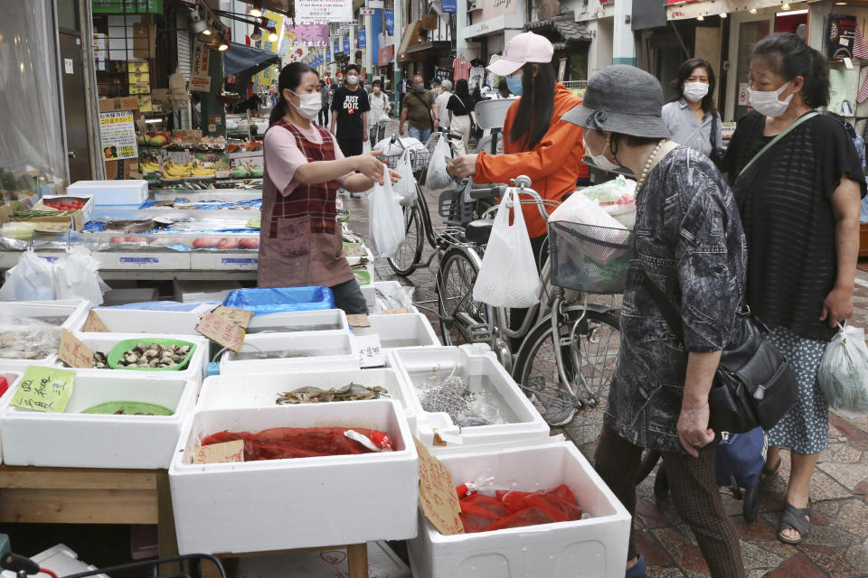 People wearing face masks shop at a mall in Yokohama, near Tokyo, Tuesday, June 23, 2020. Japan’s economy is opening cautiously, with social-distancing restrictions amid the coronavirus pandemic. (AP Photo/Koji Sasahara)