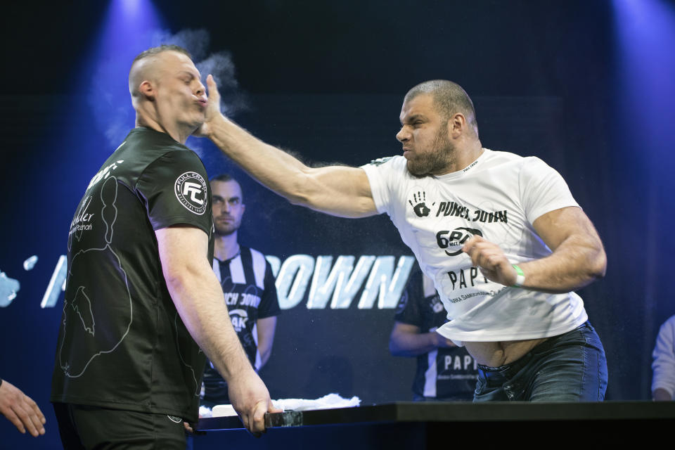 In this March 7, 2020, handout photo provided by Punch Down, Przemyslay "Sutek" Sutkowski, left, and Lukasz "Dunaj" Dunajko compete in the Punch Down slap fight event in Poznan, Poland. Slap fighting, the art of striking another fighter with an open hand for sport, is the latest head-turning spectacular. (Wojciech Rogowski/PunchDown via AP)