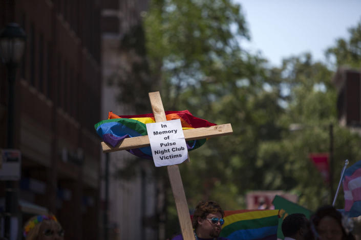 <p>Austin Ellis, a member of Metropolitan Community Church, carries a cross with a sign in memory of the victims of the Pulse nightclub shooting as he marches in the 2016 Gay Pride Parade on June 12, 2016 in Philadelphia, Pennsylvania. (Jessica Kourkounis/Getty Images) </p>